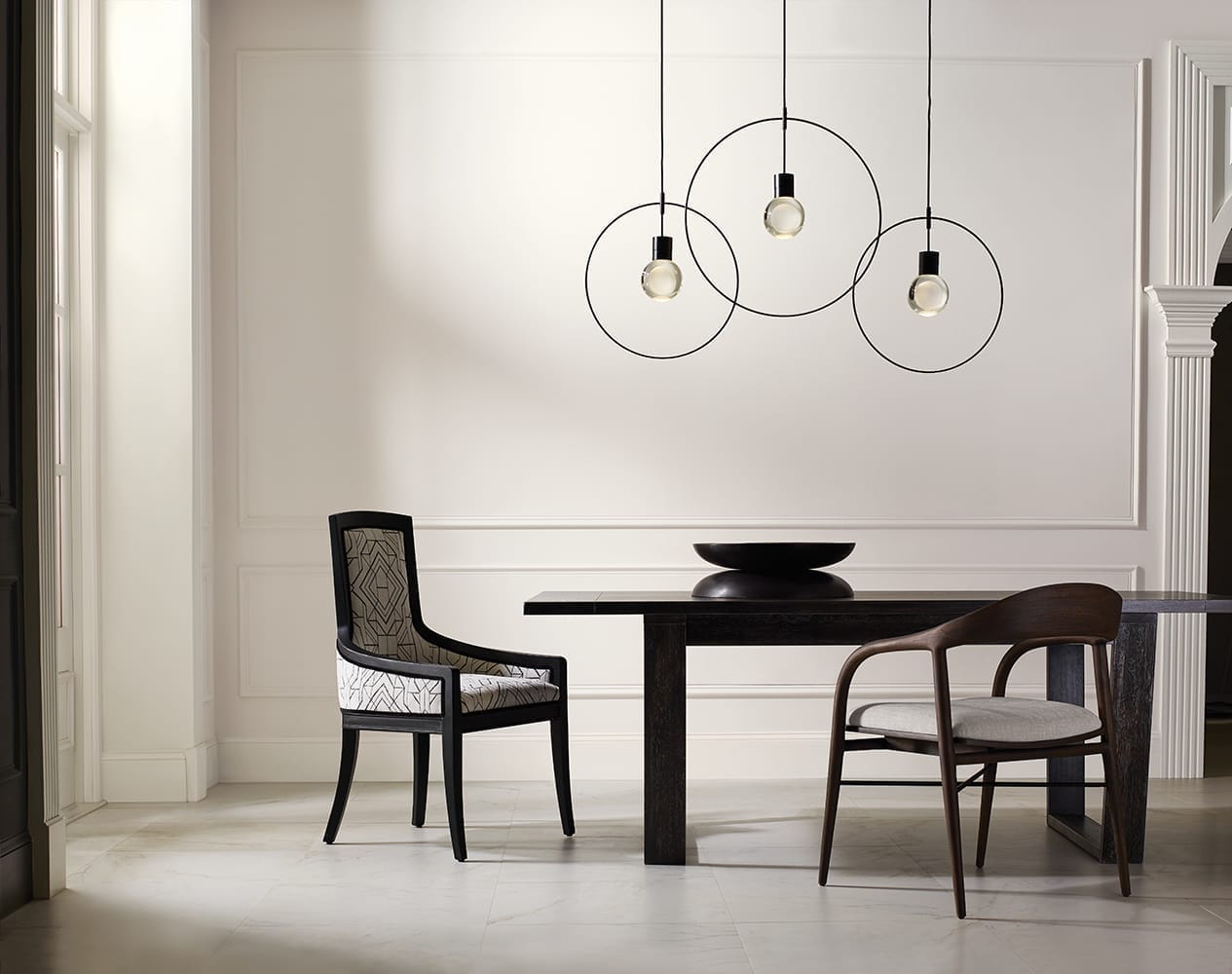 cream dining room with ebony table and modern, mismatched chairs
