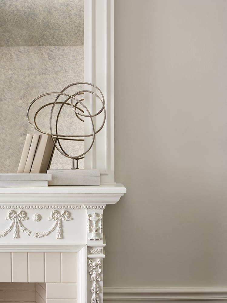 close-up of white ornate fireplace mantle against cream wall